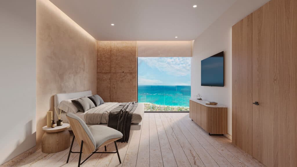 Interior view of BAO A-901 at BAO A in Puerto Morelos, a beachfront condo with a large window showcasing ocean views, a bed, a television, and minimalistic decor.