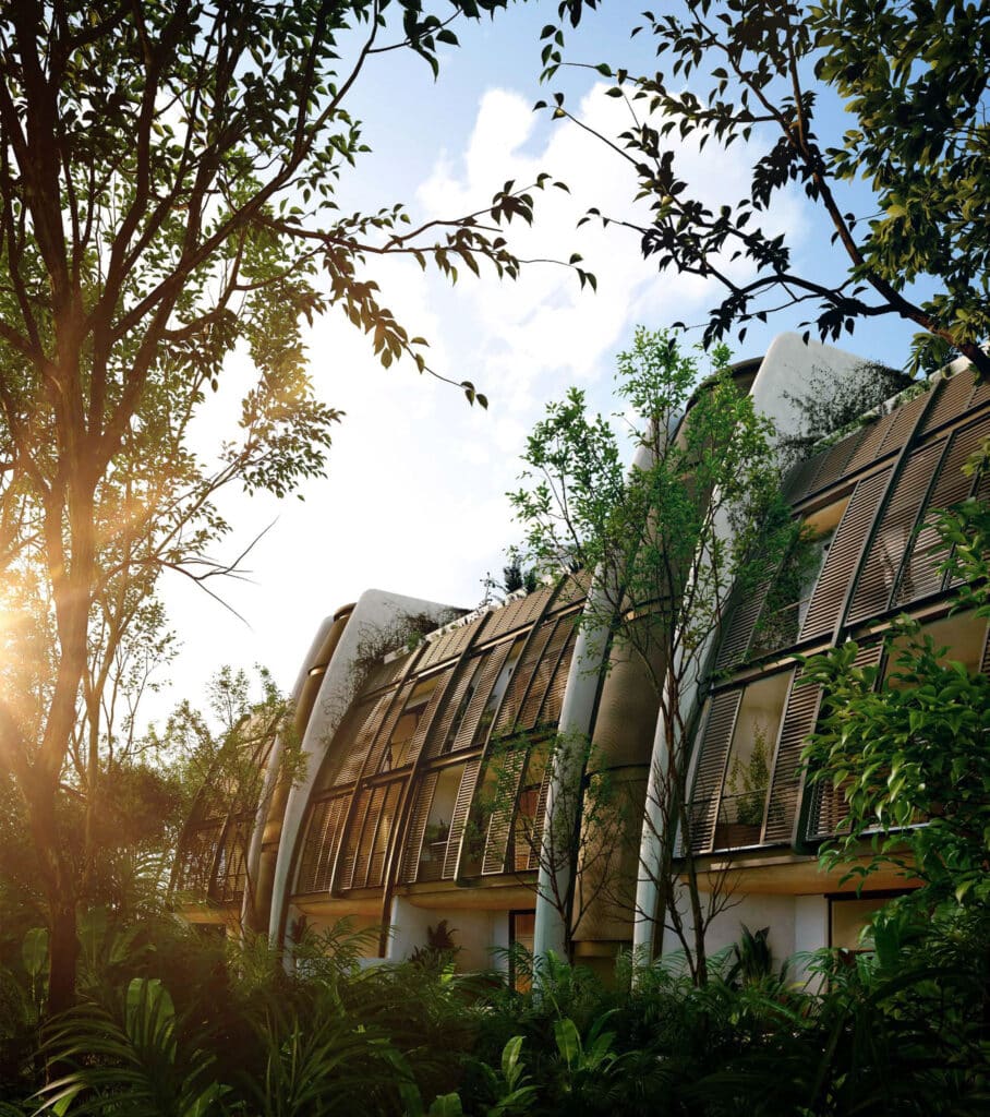 Faena District B-2303 in Tulum features a modern building with curved architectural design, surrounded by lush greenery and tall trees under a partly cloudy sky.
