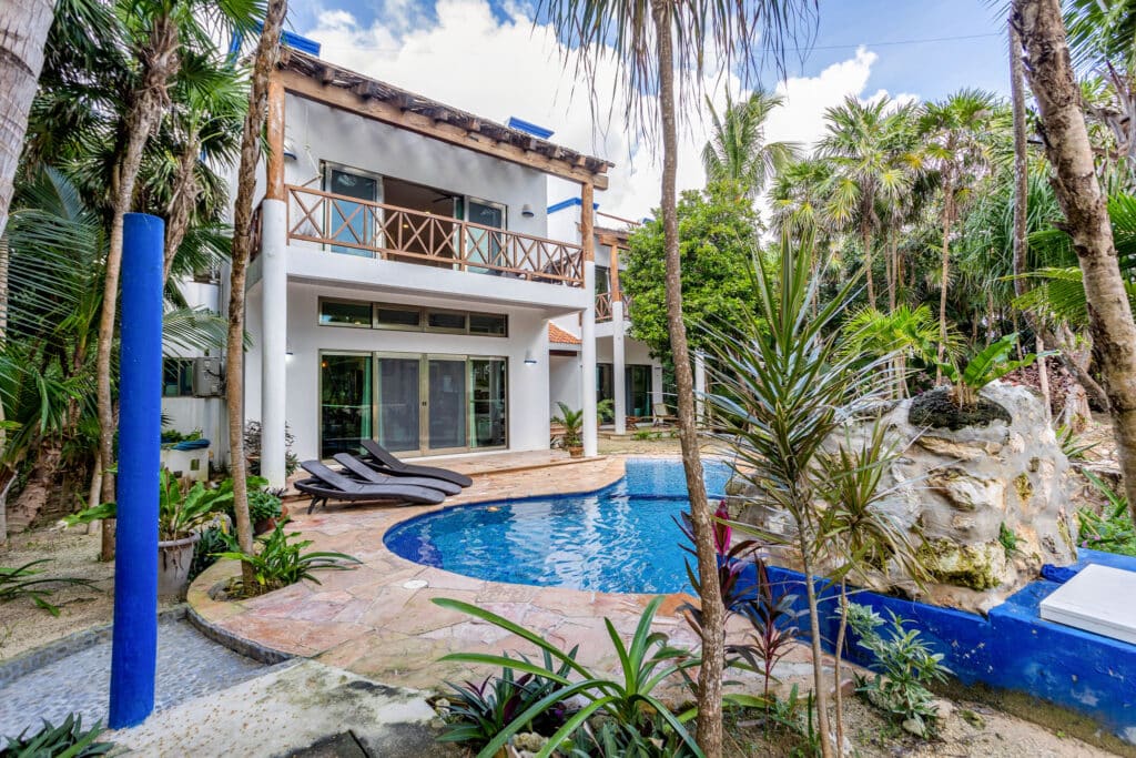 Autumns Retreats in Tulum features a villa with a private pool surrounded by lush tropical greenery and a spacious balcony overlooking the garden.