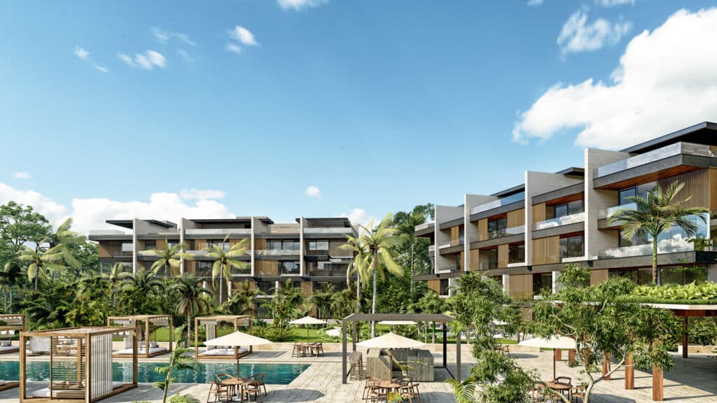 Residential buildings in the Banyan Tree Angsana A development in Merida, featuring modern architecture with multiple levels, surrounded by lush greenery and outdoor seating areas.