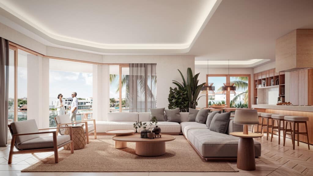 Interior view of a modern living room at Gran Peninsula I in Puerto Aventuras, featuring a large sofa, wooden accents, and windows overlooking marina front with palm trees.