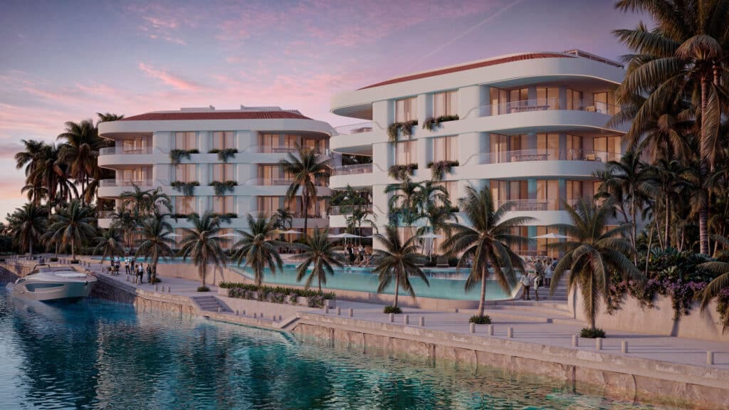 View of Gran Peninsula I-301 in Puerto Aventuras's Marina Front, featuring a modern white building with curved balconies surrounded by palm trees and a swimming pool near the water.