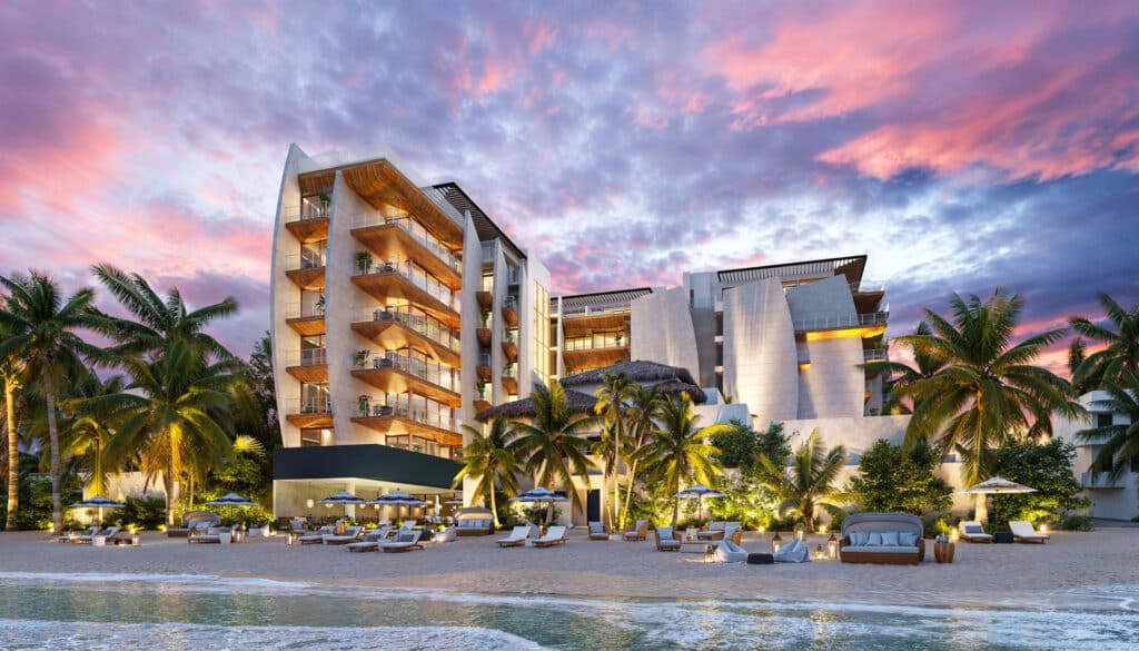Saint Marine 305 in Playa del Carmen is a beachfront residence with balconies overlooking the ocean, surrounded by palm trees and beach loungers at sunset.