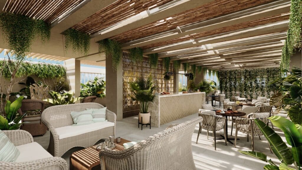 An outdoor seating area at Manglar Cumbres L in Cancun features wicker and fabric furniture, plenty of greenery, and a shaded wooden pergola, creating a cozy, lush ambiance.