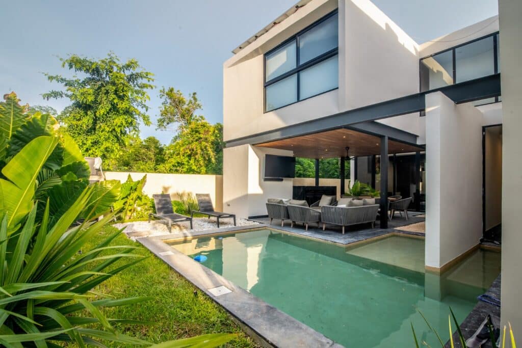 Modern Casa Orion Villa 1 in Compostela Orion 61, Merida, features an outdoor swimming pool, a covered lounge area, and lush greenery in the Santa Maria Yaxche area.