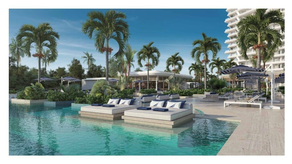Poolside lounge area at Nautica 402 in Cancun's Laguna Nichupte with palm trees, umbrellas, and modern seating.