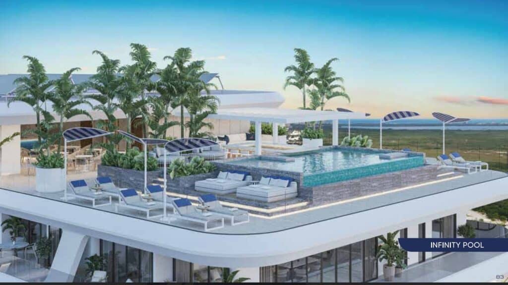 A rooftop infinity pool area with lounge chairs, umbrellas, and lush palm plants at Nautica 402 in Cancun's Laguna Nichupte area.