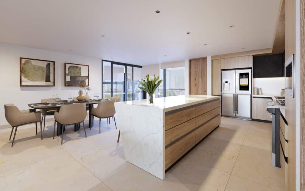 Interior view of Velmari 604 in Puerto Cancun, showing a spacious open-concept kitchen with a white marble island and a dining area with six beige chairs.
