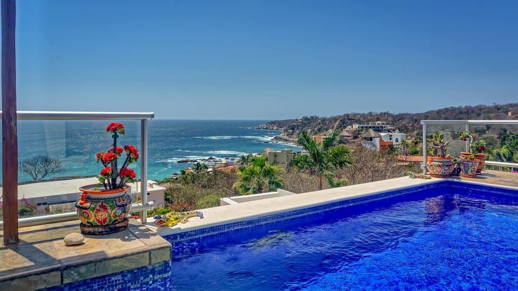 Casa Salchi house on Playa Salchi featuring a pool with ocean and hillside views in Huatulco