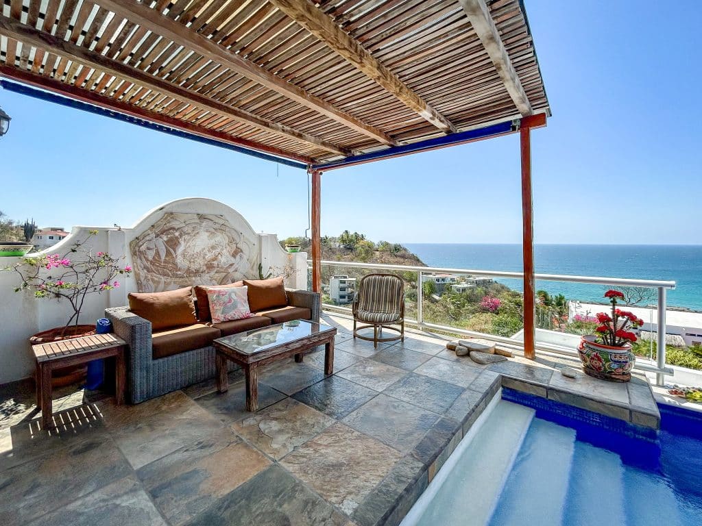 Casa Salchi Huatulco outdoor terrace with seating and ocean view, under a wooden pergola, in Playa Salchi area