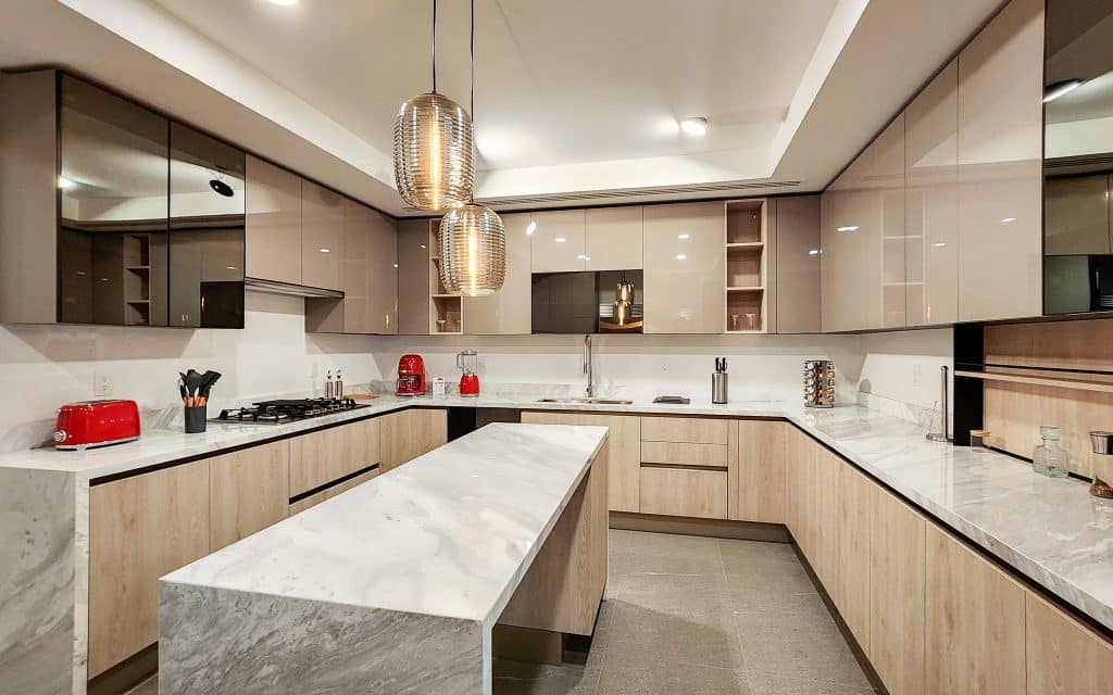Modern kitchen with beige cabinets, marble countertops, and pendant lighting in Sky View Condo, Naucalpan De Juarez, Mexico City.