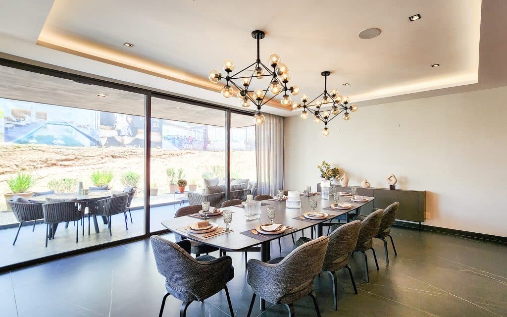 Interior of Sky View Condo in Naucalpan De Juarez, Mexico City, featuring a modern dining area with a large table, stylish chairs, and a decorative pendant light fixture.
