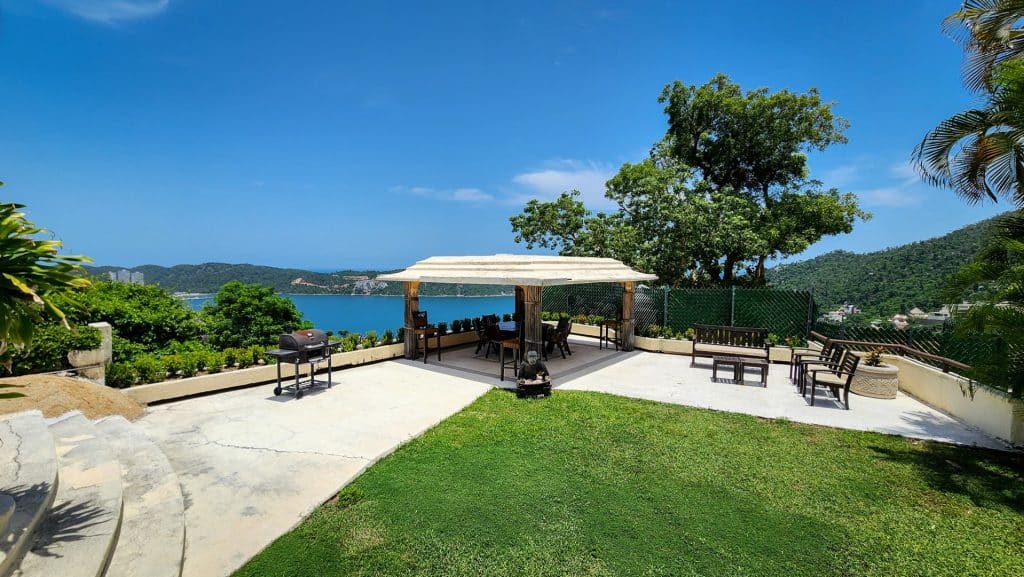 View of outdoor terrace with seating and barbecue, overlooking Acapulco Bay from Lomas Del Marques House