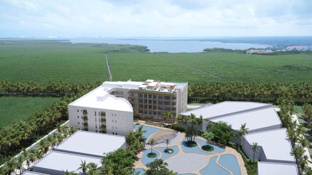 Aerial view of Distrito Zen Cancun 407 development in Puerto Cancun, showing the modern buildings, lush landscaping, and pool