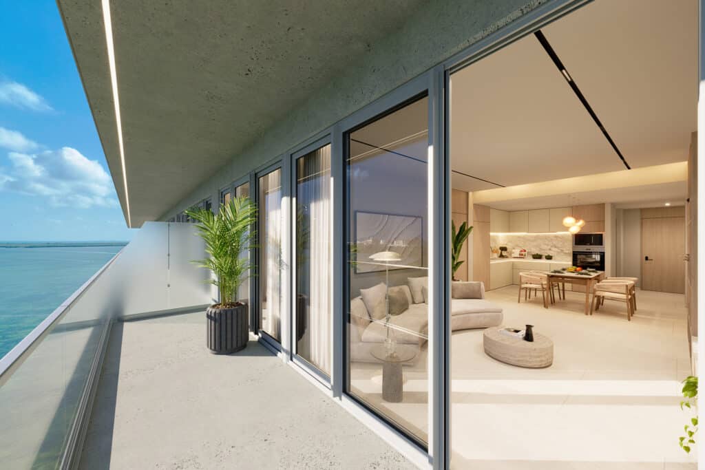 Balcony with glass railings overlooking the ocean, adjacent to a modern living room with light wood accents and minimalist decor at Bay View Grand 1419-B in Cancun.