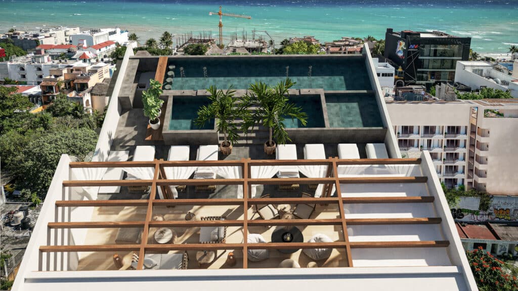 Aerial view of Petrus in Playa del Carmen showing a rooftop pool, sun loungers, and outdoor seating with ocean views in Playa Centro.
