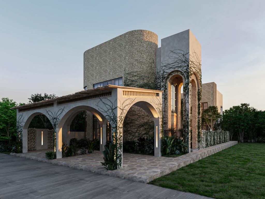 A modern house Satori Enzo Horizon, Tulum, featuring stone and concrete walls with arched openings, surrounded by greenery and landscaped gardens.