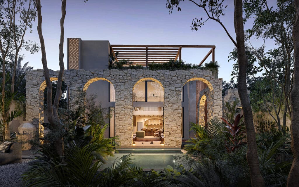 The exterior view of Satori Korin in Tulum shows a stone building with arched openings, lush greenery, and a pool, set against a twilight sky in Region 8.