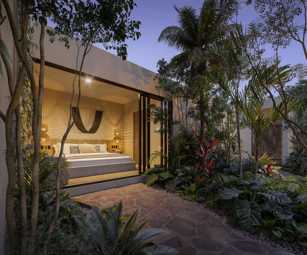 A bedroom in Satori Korin, Tulum, surrounded by lush tropical plants and trees, with warm interior lighting and modern decor as seen from the outdoor garden view.