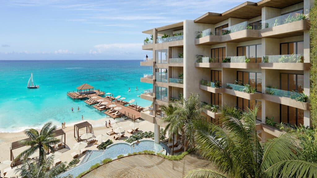 Belmare beachfront condo in Tulum features multiple terraces overlooking the ocean, with a pool and lounging area on the sandy shoreline.