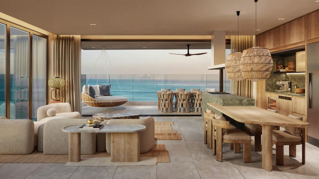 An interior shot of Belmare beachfront condo in Tulum, showcasing a modern living area with beige furniture, large windows, and a view of the ocean.