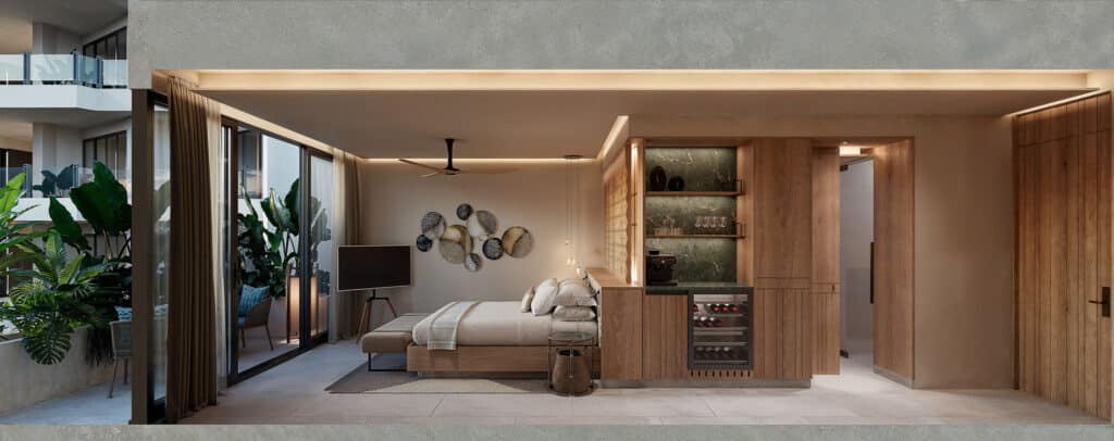 Interior view of a beachfront condo at Belmare in Tulum, showcasing a modern bedroom with wooden accents, large windows, and greenery outside.