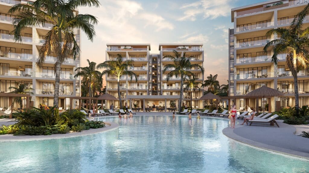 Duna Residences in Chuburna features a large pool surrounded by palm trees, loungers, and people enjoying the outdoor amenities.
