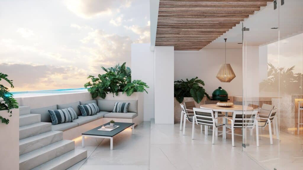 A spacious outdoor terrace at Lussela in Montecristo, Merida, featuring a built-in seating area with cushions, a dining table with chairs, and lush plants under a wooden ceiling.