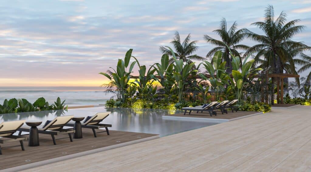 A serene beachfront view at Madeira Vida De Mar in Chicxulub, with lounge chairs by the pool and lush tropical plants during sunset.