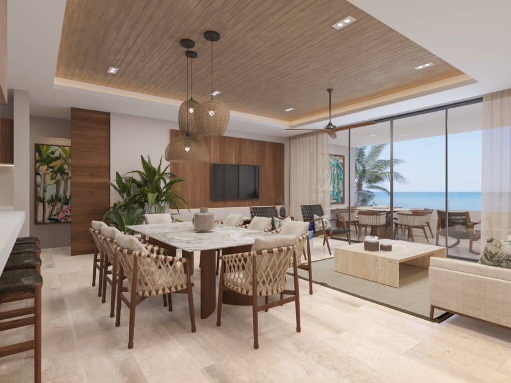 Interior view of Madeira Vida De Mar, a beachfront residence in Chicxulub, featuring a spacious dining area with a view of the outdoor terrace and ocean beyond.