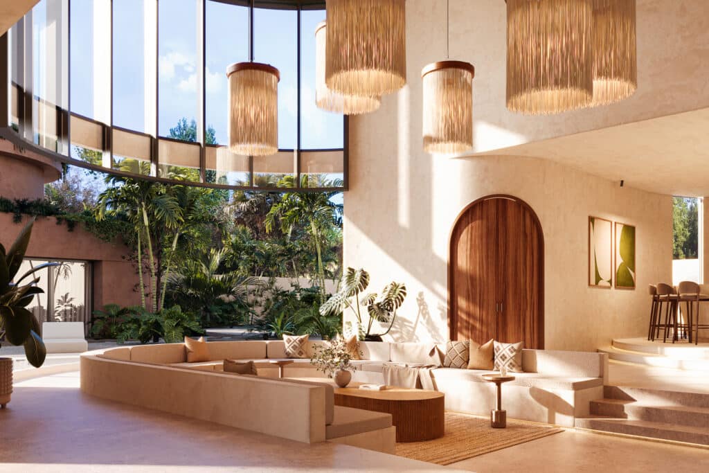 Interior view of a modern living area at Muuyal in Tulum, featuring large windows, hanging pendant lights, curved seating, and tropical plants in a bright, open space.