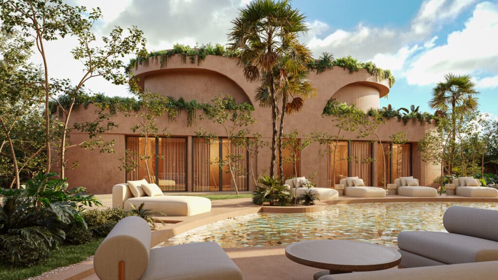 Exterior view of Muuyal in Tulum, featuring a modern pink stucco house with curved balconies, lush greenery, and a pool surrounded by lounge chairs in a tropical setting.