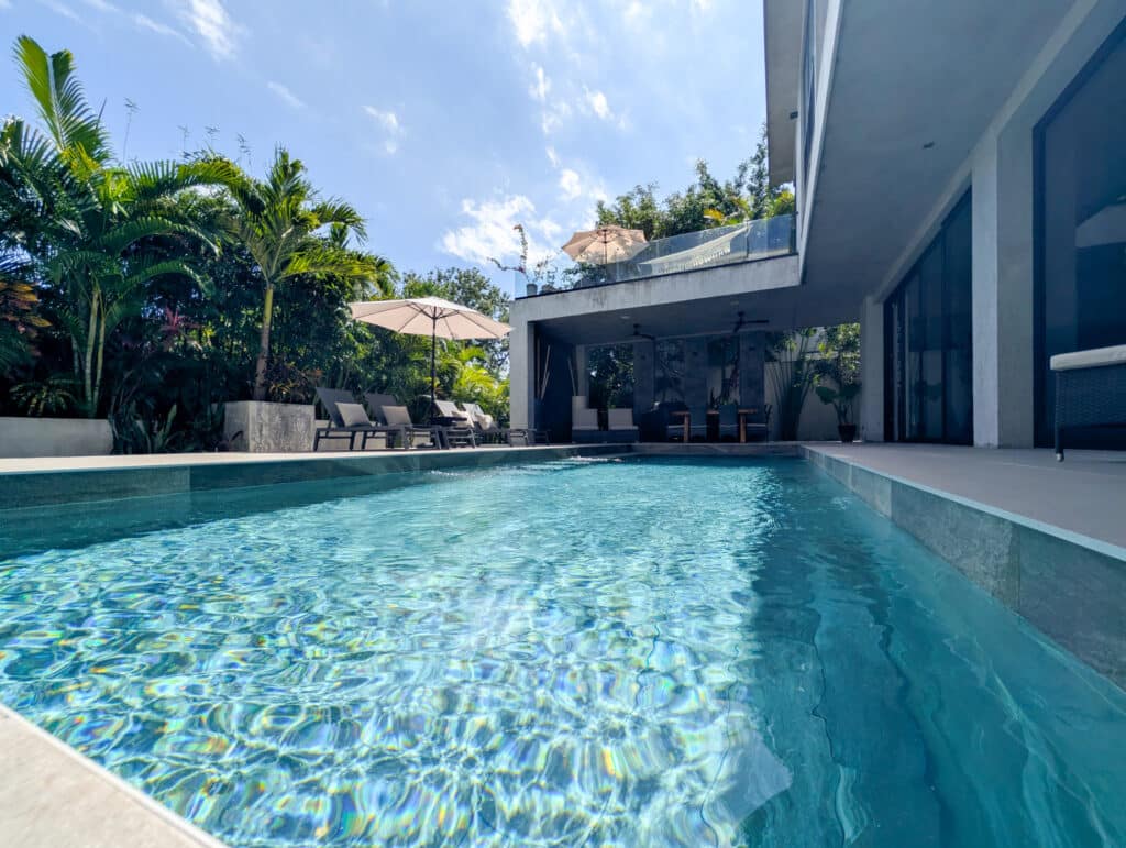 A modern house with a private pool surrounded by lush greenery at Casa Luum House in Playacar Phase 2, Playa del Carmen.