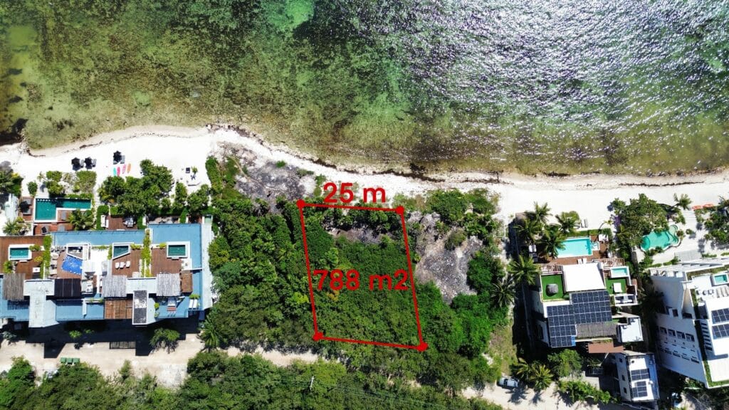 Aerial view of a beachfront lot in Tankah Bay Tulum Beachfront, Tulum, measuring 25 meters by 788 square meters, with neighboring properties and a sandy beach shoreline.