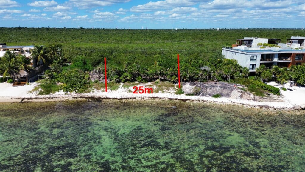 A beachfront lot in Tankah Bay Tulum, with a 25-meter wide plot facing the clear waters and lush green surroundings in Tulum.