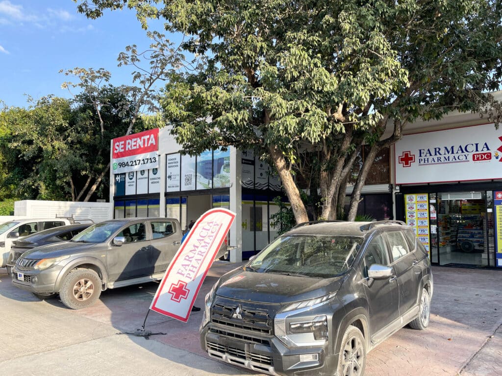 Commercial space for rent at Prime Highway Commercial Space in Puerto Aventuras, with parking and nearby pharmacy visible in the image.