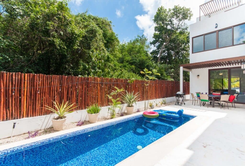View of a private pool with inflatable rings, potted plants, and outdoor seating at Casa Bahamas in Tulum's neighborhood. in Tulum Country Club.