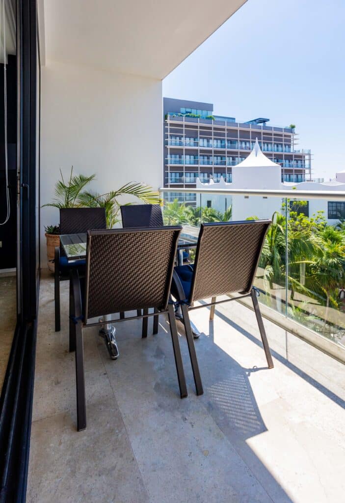 Balcony with outdoor dining set, overlooking lush greenery and modern buildings at Menesse 301 apartment for rent on Coco Beach at Menesse 301 2-Bedroom Condo.