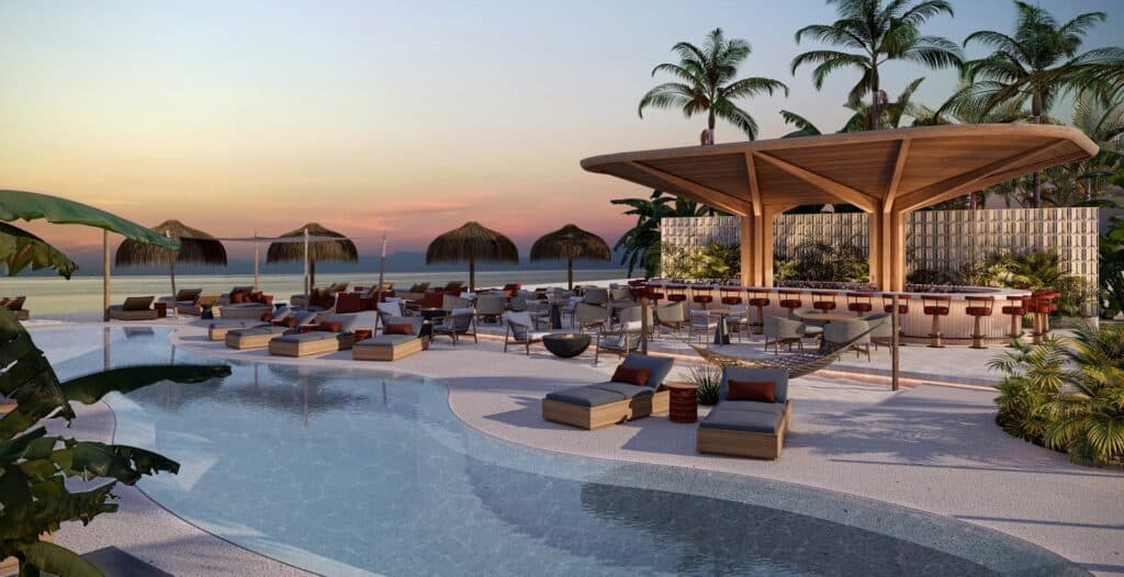 Luxury poolside bar area with loungers, wooden umbrellas, and tropical plants at sunset at Viceroy Residences in Playa del Carmen.