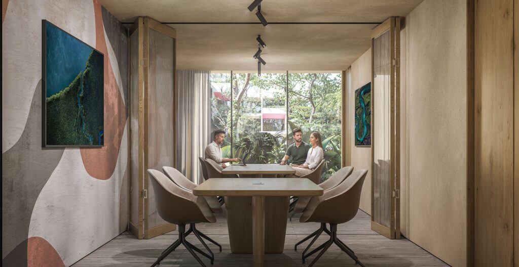 Interior of a modern conference room with wooden doors, wall art, and large window overlooking greenery at Viceroy Residences in Playa del Carmen.